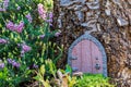 Little fairy tale door made from clay in a tree trunk with small chair Royalty Free Stock Photo