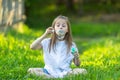 Little fanny girl blowing bubbles sitting on the grass.