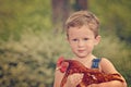 Little farm boy holding red chicken