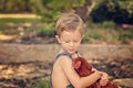 Little farm boy holding red chicken