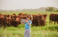 Little farmer kid with tablet near cows farm. Summer kids at countryside. Children at farm. Organic meat, milk, food.