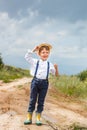 Little farmer on a summer field, cute little boy in a straw hat. boy with a flower stands in a field Royalty Free Stock Photo