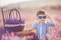 Little fashionable boy having fun in lavender summer field.