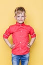 Little fashionable child with pink shirt. Fashion model. Spring. Summer. Studio portrait over yellow background Royalty Free Stock Photo