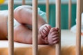 Little feet and cute toes of the 4 months old baby in the baby crib