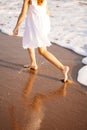 Little feet leave footprints on sandy shore of sea. walks on beach