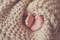 Little feet a newborn baby in a beige blanket Royalty Free Stock Photo