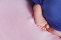 Little feet a newborn baby looking out from under blanket