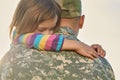 Little female child is hugging a soldier.