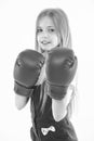 Little fighter before combat. Girl with long blond hair wearing huge red boxing gloves, sport concept. Kid in pink