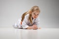 A little fighter stands on a plank during karate training. Little girl in kimono