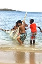 Little fishermen team with net trying caught fish