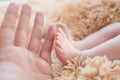 Little foot in hand. Father holding the legs of a newborn in his hands. Mom cares for the baby after taking a bath. Parents to Royalty Free Stock Photo