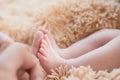 Little foot in hand. Father holding the legs of a newborn in his hands. Mom cares for the baby after taking a bath. Parents to Royalty Free Stock Photo