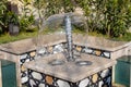 Little fountain. Transparent falling water vertical flows, close up Royalty Free Stock Photo