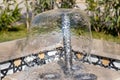 Little fountain. Transparent falling water vertical flows, close up Royalty Free Stock Photo