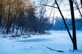 Little frozen winter lake, first sun rays play on forest trees, outdoor active hobby, popular hiking route