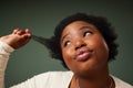 A little fun wouldnt hurt. Shot of an attractive young woman feeling flirty while posing against a green background in