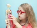 Little girl with glasses explore the structure of human body. Royalty Free Stock Photo