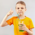 Little funny boy drinking fresh green lemonade through a straw Royalty Free Stock Photo