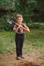 Little funny boy with shovel in garden Royalty Free Stock Photo