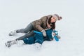 Little funny boy skating in the park and fell with his mother. Learn to Play ice hockey with stick. Outdoor. Winter Royalty Free Stock Photo