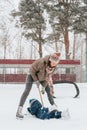 Little funny boy skating in the park and fell with his mother. Learn to Play ice hockey with stick. Outdoor. Winter Royalty Free Stock Photo