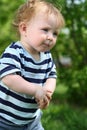 Little funny boy in striped T-shirt stands on