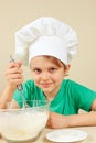 Little funny chef shuffles dough for baking cake Royalty Free Stock Photo