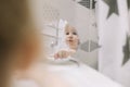little funny girl brushing teeth and washing hands in the bathroom, reflection in the mirror. Royalty Free Stock Photo