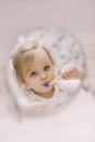 little funny girl brushing teeth and washing hands in the bathroom, reflection in the mirror. Royalty Free Stock Photo