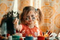 Little funny girl drawing paint with paint of face. Royalty Free Stock Photo