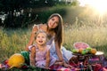 Little funny girl with her mother on a summer picnic with fruit and watermelon Royalty Free Stock Photo