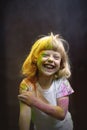 Little funny girl playing with Holi colors.