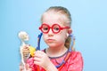 Little funny girl with red glasses listen heart with stethoscope