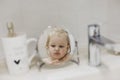 reflection in the mirror of a little funny girl washing hands and face in the bathroom Royalty Free Stock Photo