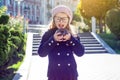 Little funny girl wearing glasses with pleasure eating chocolate donut Royalty Free Stock Photo