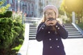 Little funny girl wearing glasses with pleasure - eating a chocolate donut Royalty Free Stock Photo