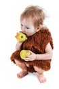 Little funny Neanderthal boy in a suit with dirty face eating an apple. Royalty Free Stock Photo