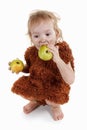 Little funny Neanderthal boy in a suit with dirty face eating an apple. Royalty Free Stock Photo