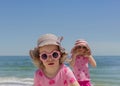 Little funny sisters girls 3 and 4 years old at the sea wearin