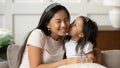 Little funny vietnamese ethnicity kid girl kissing mommy.