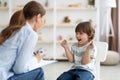 Little furious kid screaming at woman psychologist, denying communication and treatment during consultation, free space Royalty Free Stock Photo