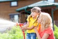 Little gardener girl with mother watering on lawn Royalty Free Stock Photo