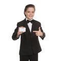 Little gentleman. Cheerful little boy in formalwear holding business card and smiling while isolated on white