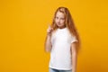 Little ginger kid girl 12-13 years old in white t-shirt isolated on bright yellow wall background children studio Royalty Free Stock Photo