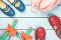 Little girl accessories. Pink bag with colorful dress and red blue shoes on blue pastel wooden background. Top view Royalty Free Stock Photo