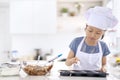 Little girl adding cream into cookies dough on mold Royalty Free Stock Photo