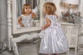 Little girl admires her reflection in mirror Royalty Free Stock Photo