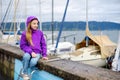 Little girl admiring beautiful yachts in a harbor of Lindau, a town on the coast of Bodensee lake in Germany on cloudy autumn day Royalty Free Stock Photo